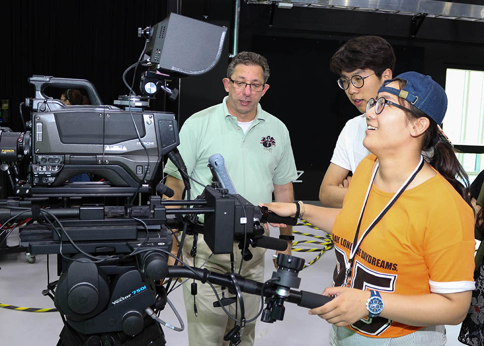 John Lombardi teaching student how to use large stupid cameras