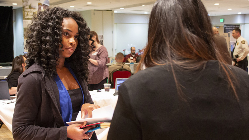 female student talking to representative at career fair